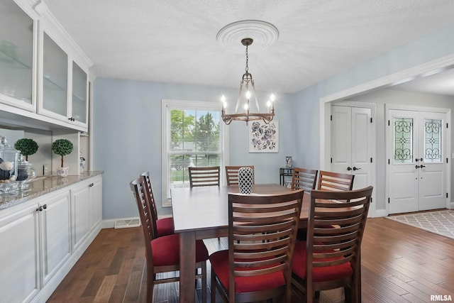 2312 Windsor Dr, Davenport, IA 52807 - dining area with dark wood-style flooring, a chandelier, baseboards, and a textured ceiling