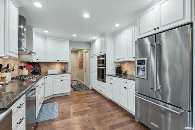 2312 Windsor Dr, Davenport, IA 52807 - kitchen with appliances with stainless steel finishes, wall chimney exhaust hood, white cabinets, recessed lighting, and decorative backsplash