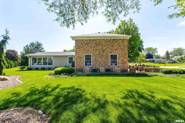 2312 Windsor Dr, Davenport, IA 52807 - rear view of house featuring a lawn and brick siding