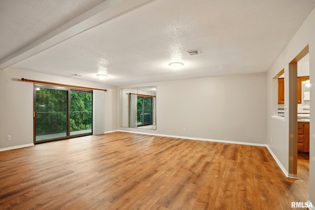 1360 Kimberly Ridge Rd Unit 306, Bettendorf, IA 52722 - spare room with light wood-type flooring, a textured ceiling, and baseboards