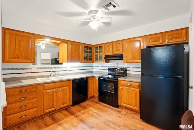 1360 Kimberly Ridge Rd Unit 306, Bettendorf, IA 52722 - kitchen with black appliances, under cabinet range hood, a sink, a ceiling fan, and brown cabinets