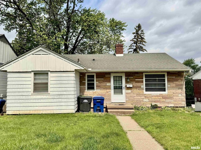 1030 Grandview Dr, Clinton, IA 52732 - ranch-style home featuring stone siding, a chimney, and a front lawn
