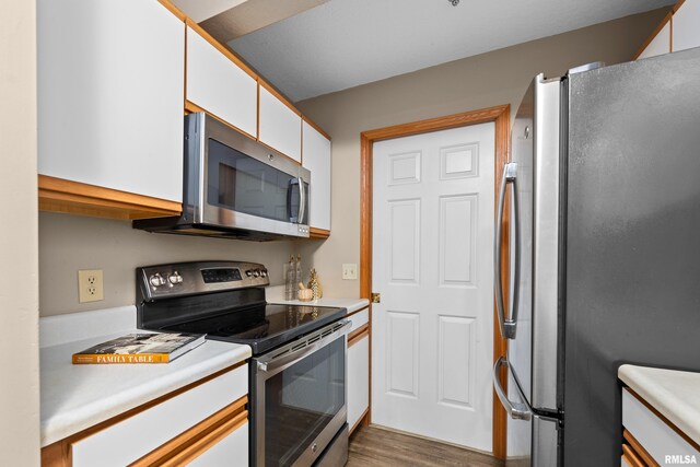 3814 Creek Hill Dr, Bettendorf, IA 52722 - kitchen with stainless steel appliances, white cabinetry, light countertops, and wood finished floors