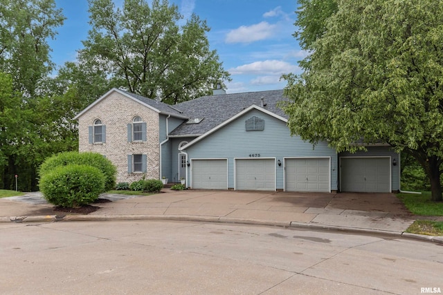 4675 Kynnelworth Dr Unit 301, Bettendorf, IA 52722 - view of front of property featuring concrete driveway, a garage, and a shingled roof