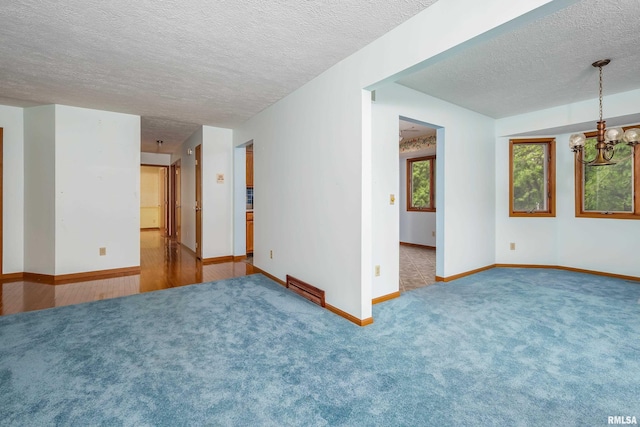 4675 Kynnelworth Dr Unit 301, Bettendorf, IA 52722 - carpeted spare room featuring a textured ceiling, a chandelier, and baseboards