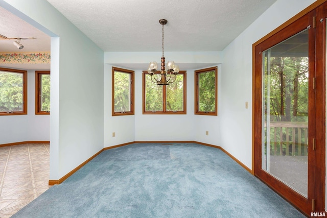 4675 Kynnelworth Dr Unit 301, Bettendorf, IA 52722 - empty room featuring plenty of natural light, a chandelier, a textured ceiling, baseboards, and carpet flooring