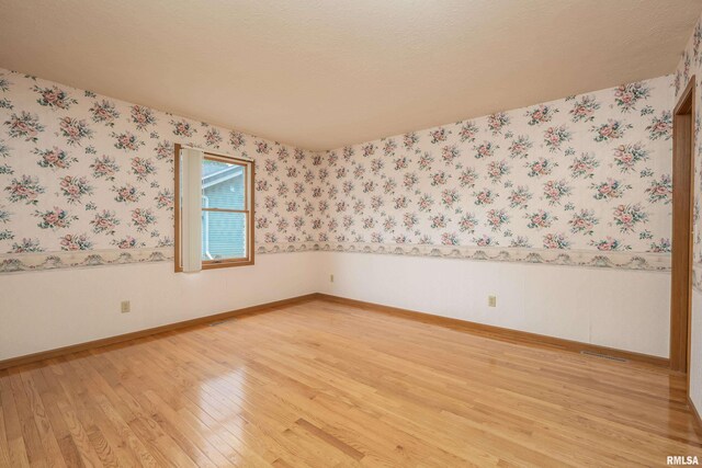 4675 Kynnelworth Dr Unit 301, Bettendorf, IA 52722 - unfurnished room with light wood-style floors, wallpapered walls, wainscoting, and baseboards
