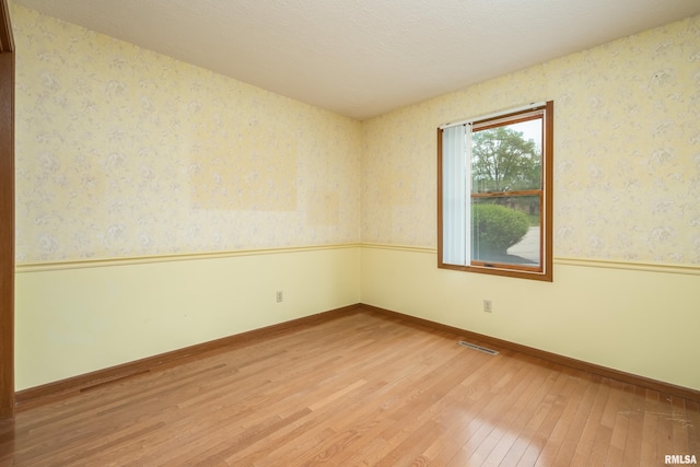 4675 Kynnelworth Dr Unit 301, Bettendorf, IA 52722 - empty room featuring wallpapered walls, light wood-style floors, and baseboards