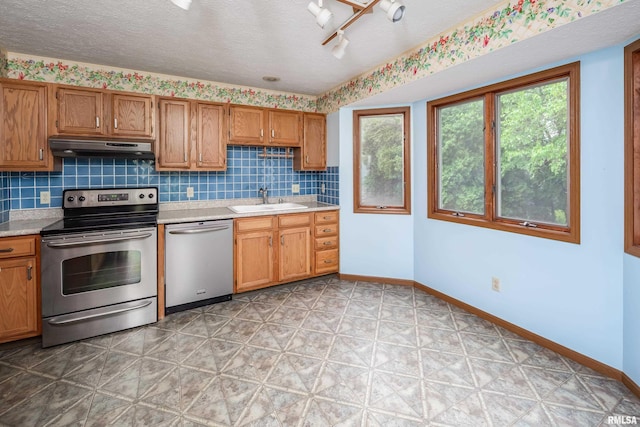 4675 Kynnelworth Dr Unit 301, Bettendorf, IA 52722 - kitchen featuring appliances with stainless steel finishes, a sink, light countertops, light floors, and a textured ceiling