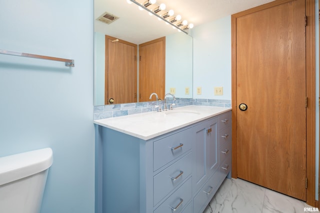4675 Kynnelworth Dr Unit 301, Bettendorf, IA 52722 - bathroom with vanity, toilet, marble finish flooring, and backsplash