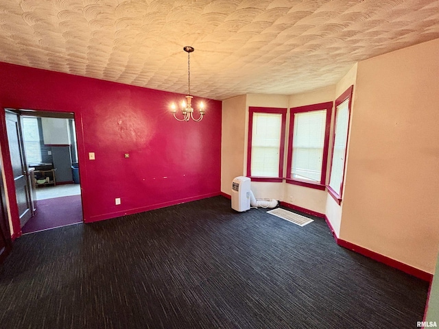 837 19th Ave, Moline, IL 61265 - unfurnished room featuring baseboards, a chandelier, carpet, and a textured ceiling