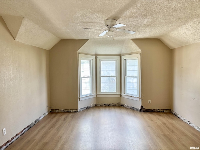 837 19th Ave, Moline, IL 61265 - bonus room featuring vaulted ceiling, a textured ceiling, wood finished floors, a ceiling fan, and baseboards