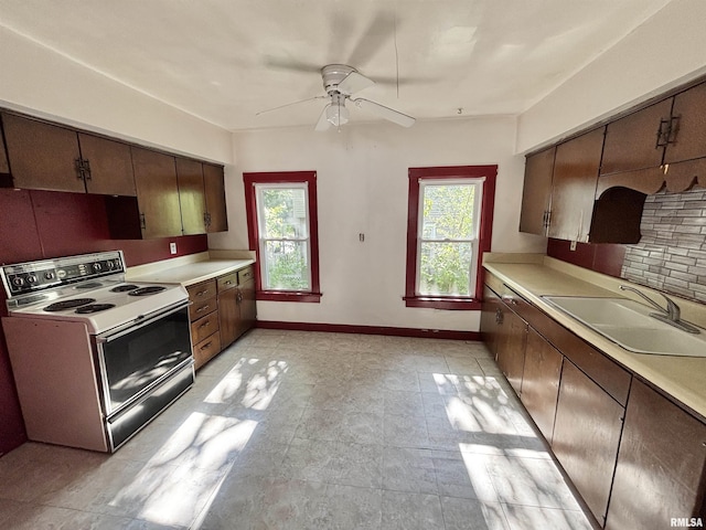 837 19th Ave, Moline, IL 61265 - kitchen with white range with electric stovetop, a sink, ceiling fan, light countertops, and baseboards