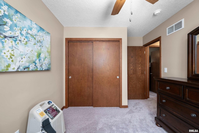 2614 W 59th St, Davenport, IA 52806 - bedroom with a closet, light carpet, a textured ceiling, and ceiling fan