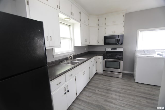 1502 N Ripley St, Davenport, IA 52803 - kitchen featuring black appliances, washer / dryer, a sink, dark countertops, and white cabinets