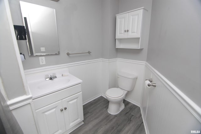 1502 N Ripley St, Davenport, IA 52803 - bathroom with toilet, a wainscoted wall, vanity, wood finished floors, and a decorative wall