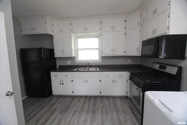 1502 N Ripley St, Davenport, IA 52803 - kitchen featuring black appliances, a sink, dark countertops, light wood-type flooring, and white cabinets