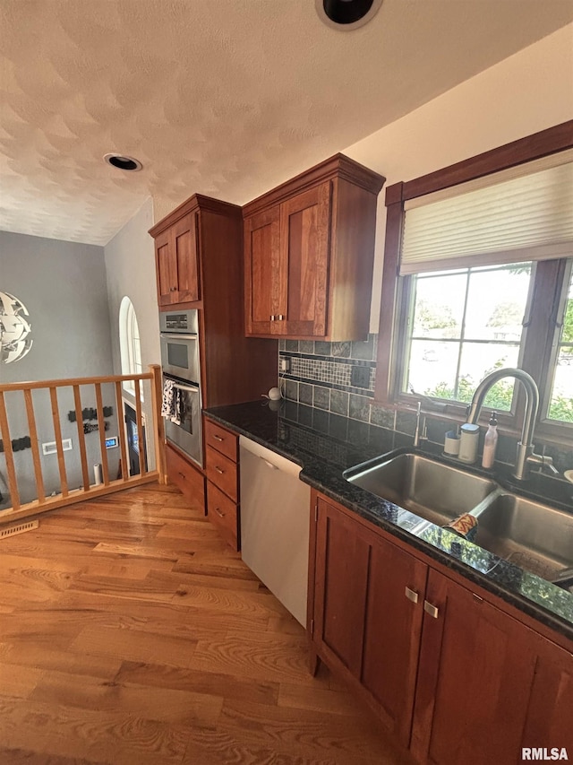 462 Circle Dr, Kewanee, IL 61443 - kitchen with a sink, appliances with stainless steel finishes, dark countertops, light wood-style flooring, and backsplash