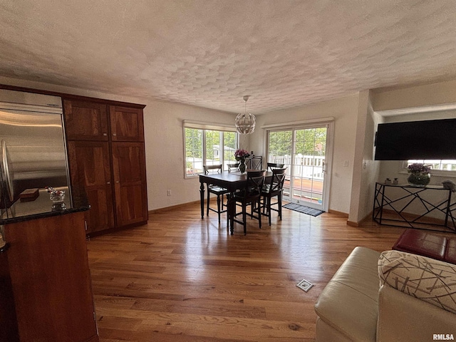 462 Circle Dr, Kewanee, IL 61443 - dining area featuring a textured ceiling, wood finished floors, baseboards, and a chandelier