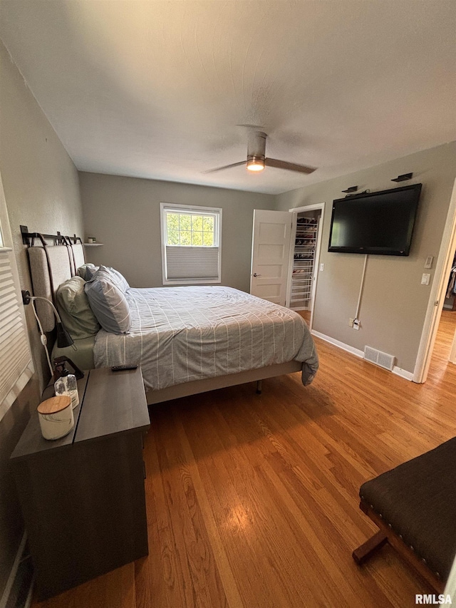 462 Circle Dr, Kewanee, IL 61443 - bedroom featuring wood finished floors, baseboards, a walk in closet, and a ceiling fan