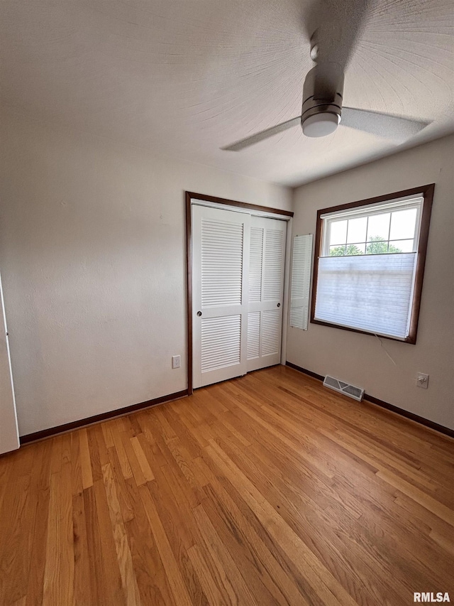 462 Circle Dr, Kewanee, IL 61443 - unfurnished bedroom with light wood finished floors, baseboards, a ceiling fan, and a closet