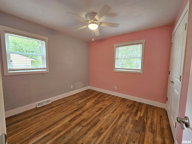 4325 N Lincoln Ave, Davenport, IA 52806 - unfurnished bedroom with wood finished floors, baseboards, a closet, and a ceiling fan