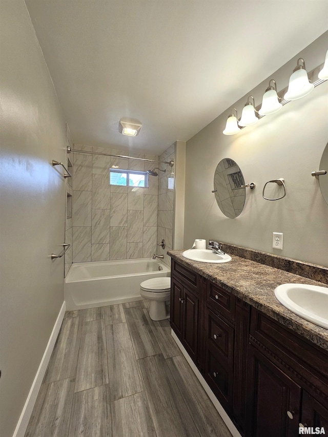 4325 N Lincoln Ave, Davenport, IA 52806 - bathroom featuring toilet, double vanity, washtub / shower combination, and wood finished floors