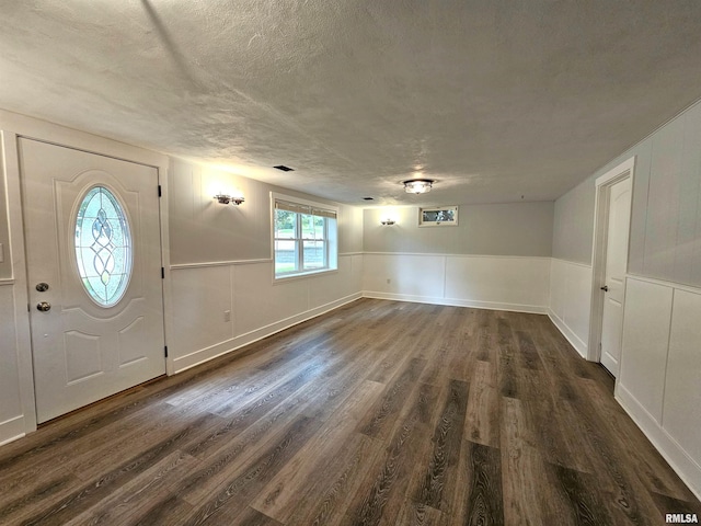 4325 N Lincoln Ave, Davenport, IA 52806 - foyer with dark wood-style floors, a textured ceiling, a decorative wall, and a wainscoted wall