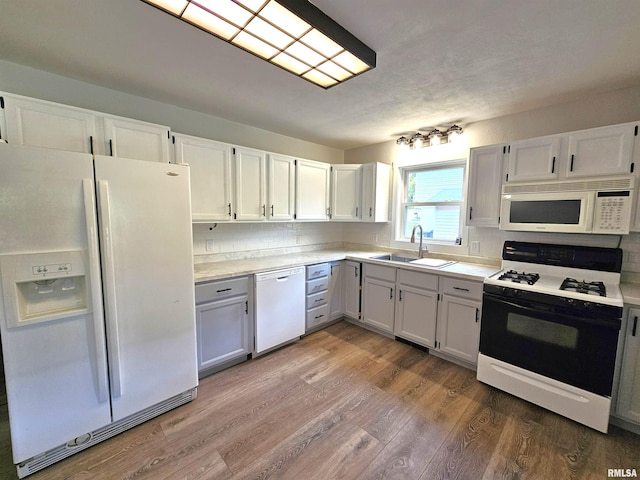 4325 N Lincoln Ave, Davenport, IA 52806 - kitchen featuring white appliances, a sink, light wood-style floors, light countertops, and decorative backsplash