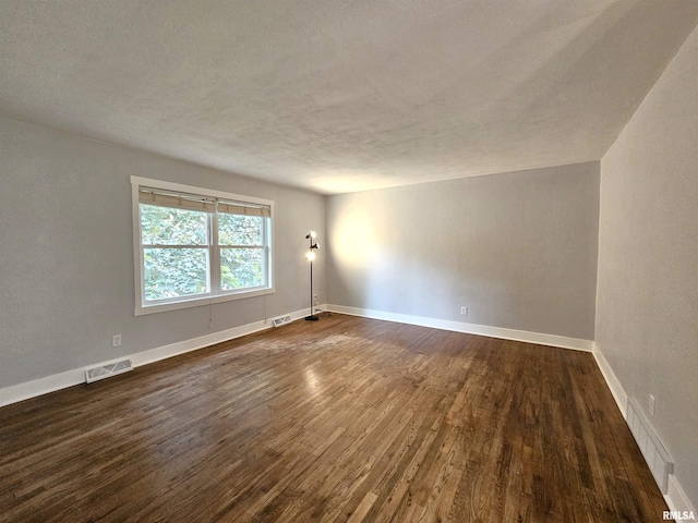 4325 N Lincoln Ave, Davenport, IA 52806 - unfurnished room featuring dark wood-style flooring, baseboards, and a textured ceiling