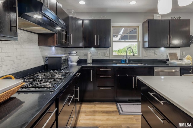 3160 Sycamore Rd, Carterville, IL 62918 - kitchen featuring a sink, dishwasher, under cabinet range hood, tasteful backsplash, and light wood finished floors