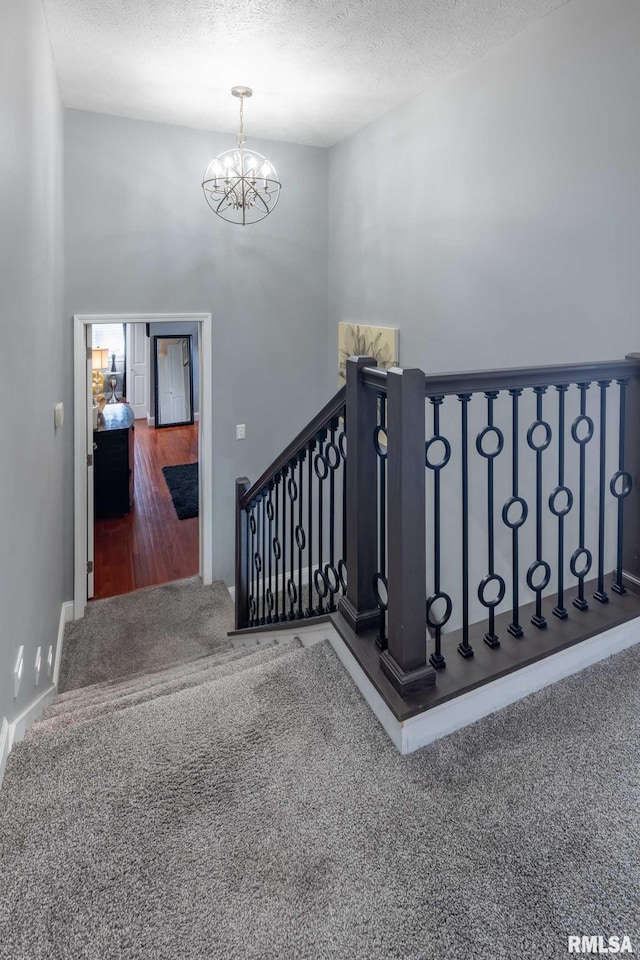 3160 Sycamore Rd, Carterville, IL 62918 - stairs featuring carpet floors, a textured ceiling, a chandelier, and baseboards