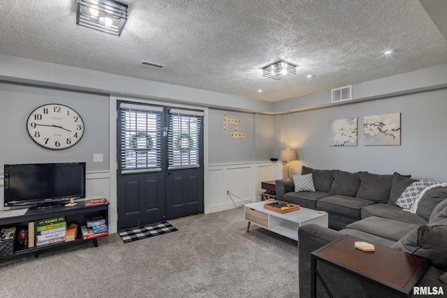 3160 Sycamore Rd, Carterville, IL 62918 - living room featuring a textured ceiling, carpet, a decorative wall, and wainscoting