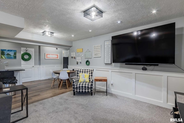 3160 Sycamore Rd, Carterville, IL 62918 - carpeted living room featuring a textured ceiling, a decorative wall, and wainscoting