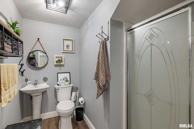 3160 Sycamore Rd, Carterville, IL 62918 - full bath with wood finished floors, toilet, a stall shower, baseboards, and a textured ceiling