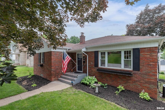 807 Spalding Blvd, Davenport, IA 52804 - view of front of house featuring a chimney, a front lawn, brick siding, and roof with shingles