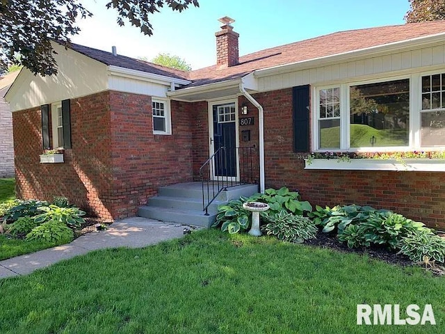 807 Spalding Blvd, Davenport, IA 52804 - entrance to property with a chimney, a yard, and brick siding