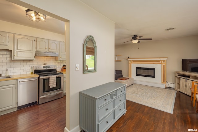 807 Spalding Blvd, Davenport, IA 52804 - kitchen with stainless steel appliances, under cabinet range hood, dark wood finished floors, ceiling fan, and baseboard heating
