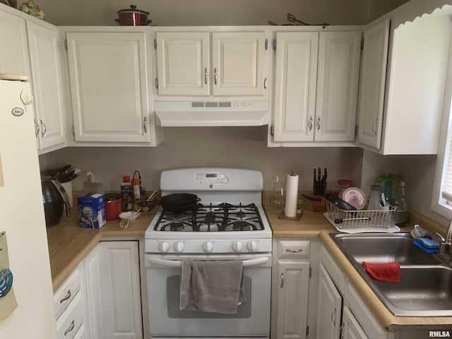 1424 29th Ave, Moline, IL 61265 - kitchen with white gas stove, under cabinet range hood, refrigerator, light countertops, and white cabinetry