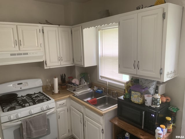 1424 29th Ave, Moline, IL 61265 - kitchen with white gas stove, under cabinet range hood, and white cabinetry