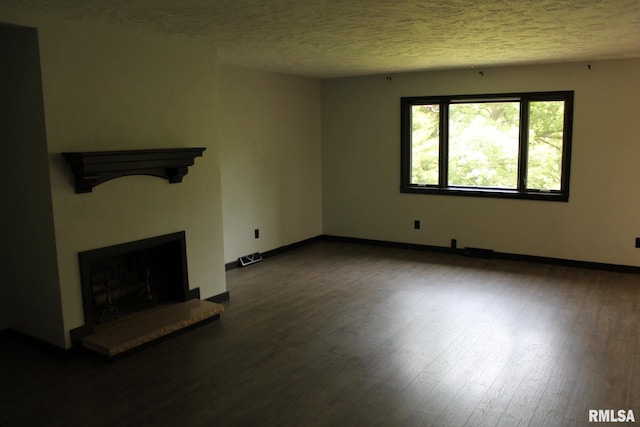 24176 Stagecoach Rd, Geneseo, IL 61254 - unfurnished living room with wood finished floors, a fireplace with raised hearth, a textured ceiling, and baseboards