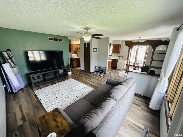 709S 4th St S, Maquoketa, IA 52060 - living room with a textured ceiling, a ceiling fan, and wood finished floors