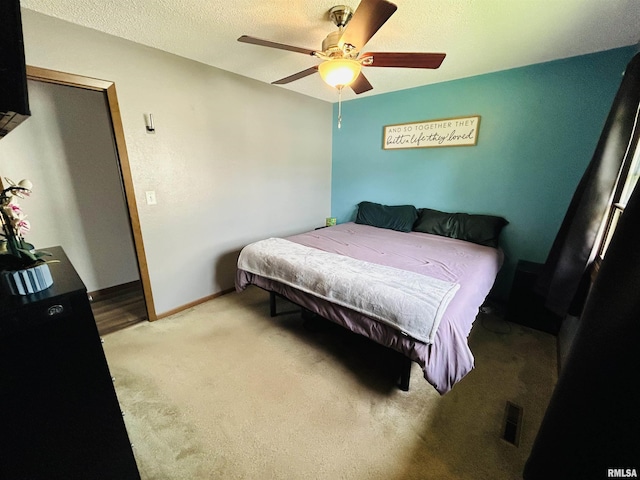 709S 4th St S, Maquoketa, IA 52060 - bedroom featuring light carpet, ceiling fan, and a textured ceiling