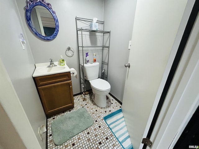 709S 4th St S, Maquoketa, IA 52060 - half bathroom with toilet, vanity, tile patterned flooring, and baseboards