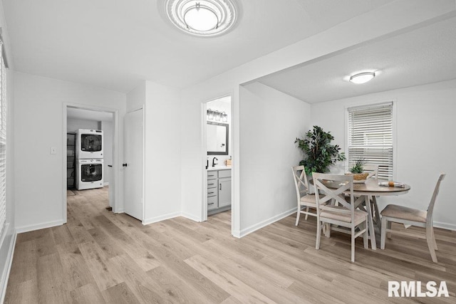 1156 23rd St, Moline, IL 61265 - dining room featuring stacked washing machine and dryer and light wood-style flooring