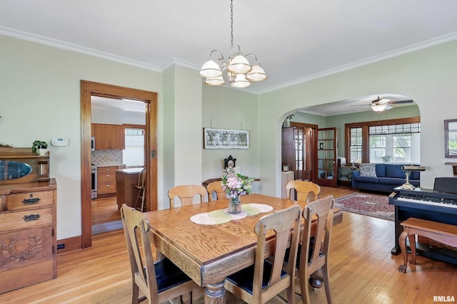 924 Brown St, Bettendorf, IA 52722 - dining space featuring arched walkways, light wood finished floors, crown molding, a chandelier, and a ceiling fan