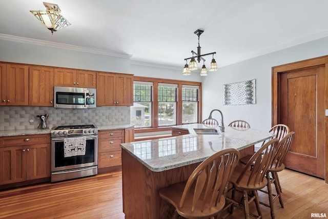 924 Brown St, Bettendorf, IA 52722 - kitchen with appliances with stainless steel finishes, brown cabinets, decorative backsplash, a chandelier, and a kitchen breakfast bar