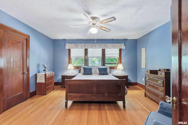 924 Brown St, Bettendorf, IA 52722 - bedroom with light wood-style floors, baseboards, a textured ceiling, and ceiling fan