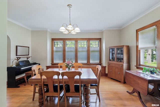 924 Brown St, Bettendorf, IA 52722 - dining room featuring light wood-type flooring, ornamental molding, a chandelier, arched walkways, and baseboards
