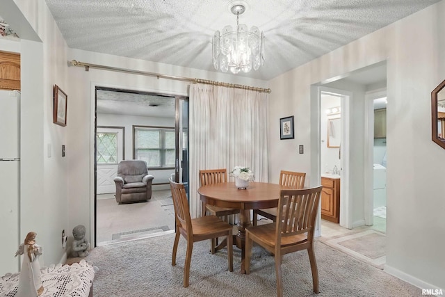 1119 14th St, Bettendorf, IA 52722 - dining space featuring light colored carpet, a textured ceiling, and a chandelier